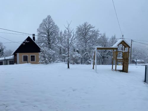 a snow covered field with a basketball hoop at Holiday home Maklen with big garden and jacuzzi in Brod Moravice