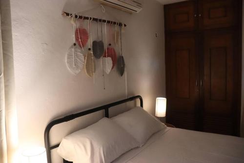 a bedroom with a bed with a white pillow and some shoes at Un rinconcito en Mérida in Mérida