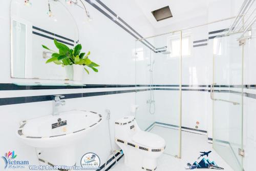 bagno con lavandino e servizi igienici di Villa Hồ Bơi HOÀNG ĐỨC BÃI SAU ĐẸP HOA GIẤY a Vung Tau