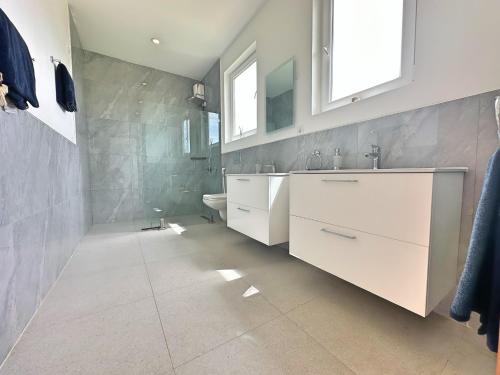 a white bathroom with a sink and a toilet at Tropical Gem: 3-BR Beach Villa in Pingwe