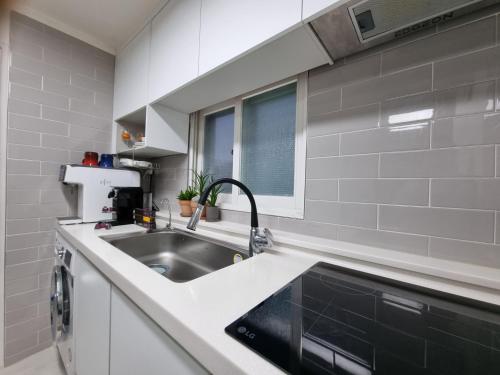 eine Küche mit einer Spüle und einer Arbeitsplatte in der Unterkunft Miz Soo House in Seoul