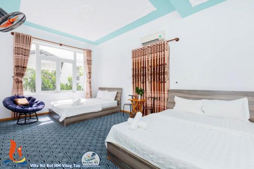 a bedroom with two beds and a chair in it at Villages HOÀNG ĐỨC Bãi Sau có bàn bida karaoke in Vung Tau