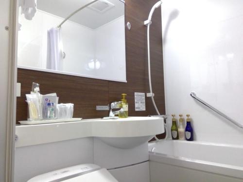 a bathroom with a toilet and a sink and a tub at Hotel Alpha-One Takayama Bypass in Takayama