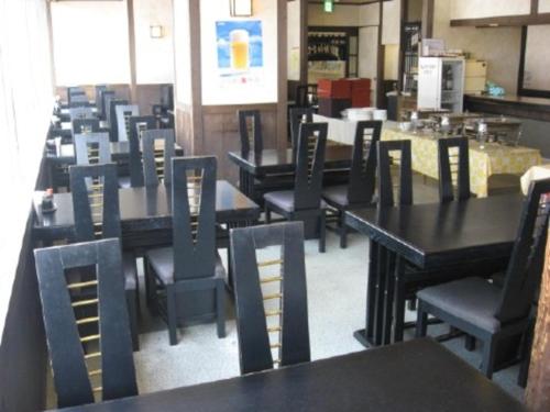 a dining room with black tables and chairs at Hotel Alpha-One Takayama Bypass in Takayama