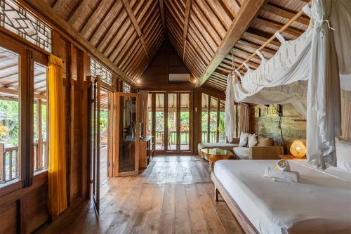 a bedroom with a bed and a couch in a room at Villa Lina by Optimum Bali Villas in Canggu