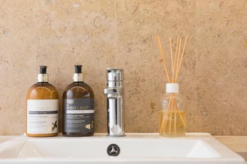 three bottles of wine sitting on a bathroom sink at Exquisite 2 Bed Soho Central Apartment Sleeps 6 in London