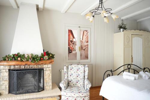 a bedroom with a fireplace and a chair next to a bed at Guesthouse Doma est 1991 in Arachova