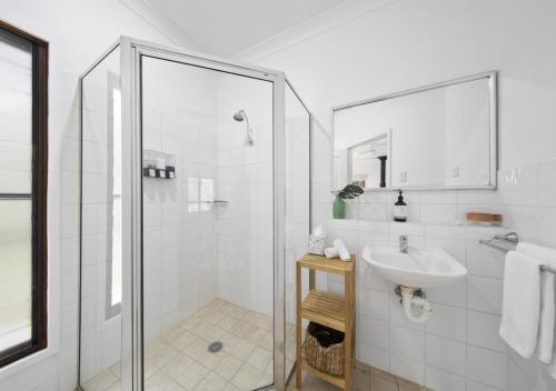 a white bathroom with a sink and a shower at Sweetacres Hunter Valley in Pokolbin