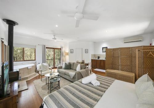 a bedroom with a bed and a living room with a couch at Sweetacres Hunter Valley in Pokolbin
