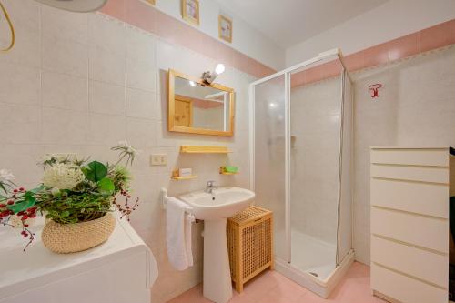 a white bathroom with a sink and a shower at Studio Grange Nest Ski & Relax - Happy Rentals in Sestriere