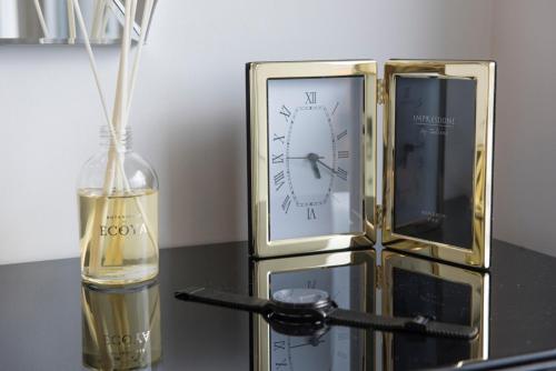 eine Flasche Champagner neben einer Uhr und eine Flasche Wein in der Unterkunft The Wentworth Apartment - Sleeps 4 in London