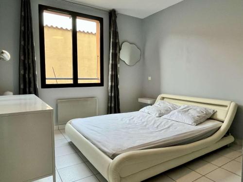 une chambre avec un lit et une fenêtre dans une pièce dans l'établissement Appartement coquet 3 pièces, centre village, proche commerces et plages, parking, wifi, 4 pers. - FR-1-225-652, à Argelès-sur-Mer
