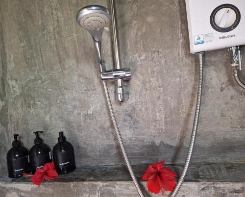 a shower with three bottles on a wall at Bamboo Surf Beach in San Isidro