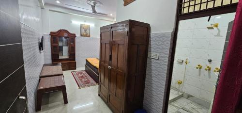baño pequeño con armario de madera y ducha en Mayur Villa, en Agra