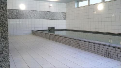 ein leeres Zimmer mit Pool in einem Gebäude in der Unterkunft Hotel Alpha-One Himeji Minamiguchi in Himeji
