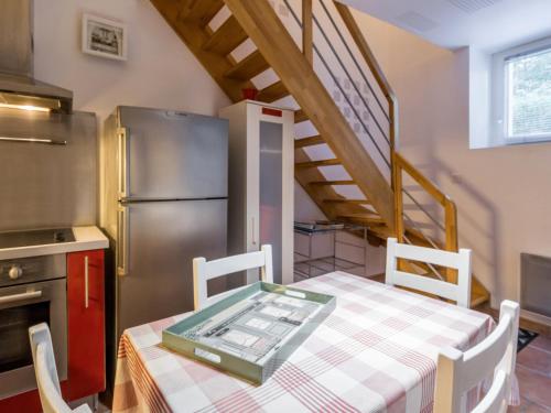 une cuisine avec une table et un réfrigérateur dans l'établissement Gîte cosy aux portes de Nantes, terrasse privée, vélos, Wifi, draps inclus - FR-1-306-824, à Saint-Sébastien-sur-Loire