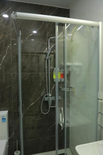 a shower with a glass door in a bathroom at Human Hotel in Tashkent