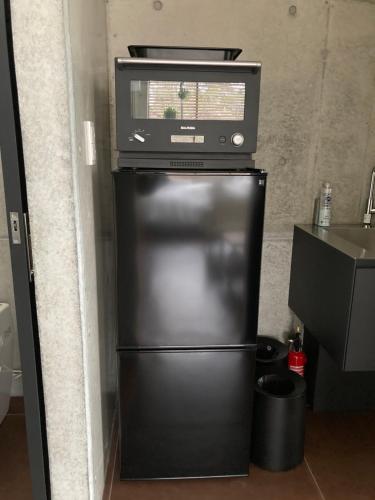 a microwave andrigerator on top of a refrigerator at G.bouquet in Nakijin