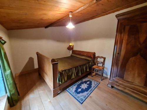 Cette chambre mansardée comprend un lit et une chaise. dans l'établissement Gîte Benet, 5 pièces, 8 personnes - FR-1-426-146, à Benet