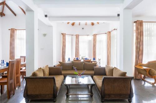 a living room with a couch and a table at Aaradhya Nuwara Eliya in Nuwara Eliya