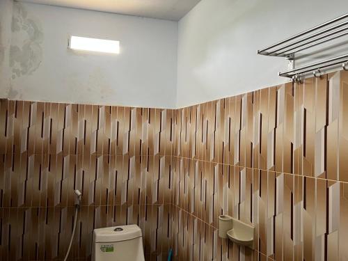 OYO 91857 Callista Homestay في Bonthain: حمام به مرحاض وجدران خشبية