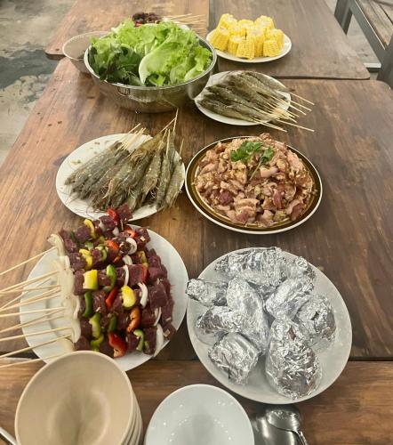 a wooden table with plates of food on it at Lux Nest Villa Đà Lạt in Da Lat