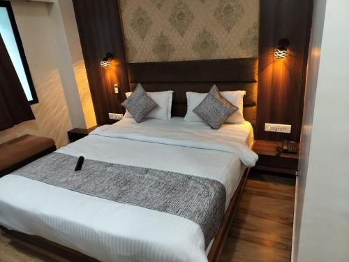 um quarto de hotel com duas camas com lençóis brancos em HOTEL RJ RESIDENCY em Ahmedabad
