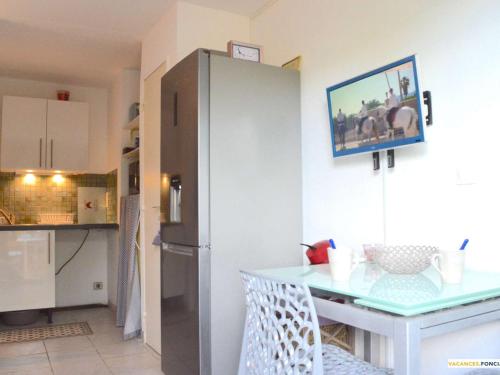 une cuisine avec un réfrigérateur et une table à l'intérieur dans l'établissement Studio avec Terrasse, Parking et Piscine, Narbonne Plage - FR-1-229B-59, à Narbonne