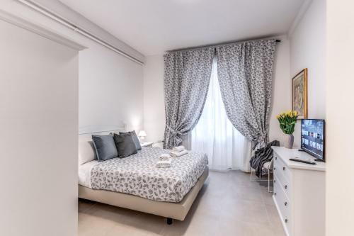 een witte slaapkamer met een bed en een raam bij PMT Apt in Rome