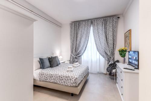 a white bedroom with a bed and a window at PMT Apt in Rome