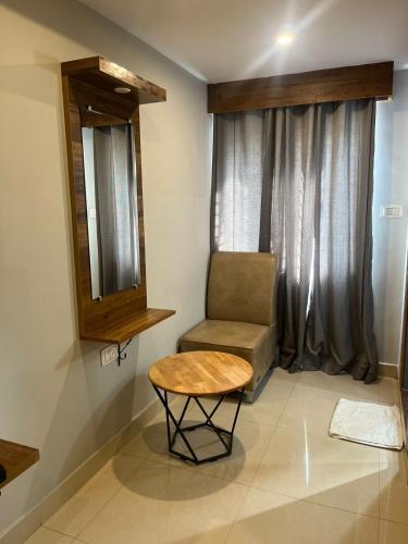 a chair and a table in a room with a window at Hotel Avenue Suites Near International Airport Bangalore in Bengaluru