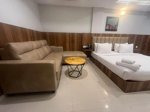 a living room with a bed and a couch at Hotel Avenue Suites Near International Airport Bangalore in Bengaluru