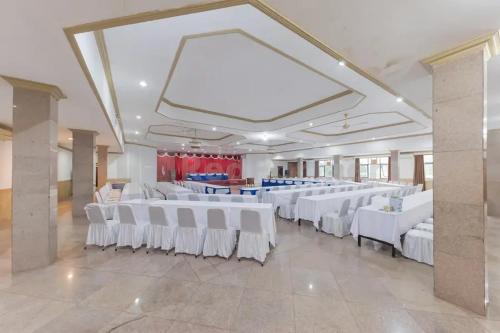 a banquet hall with white tables and white chairs at Hotel ayong Linggarjati Kuningan Mitra RedDoorz in Kuningan