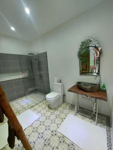 bagno con lavandino, servizi igienici e specchio di RAYA by Snooze a Yogyakarta