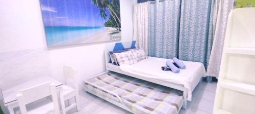un pequeño dormitorio con una cama y una pintura en HR's Residence, en Boracay