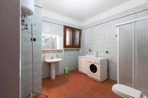een badkamer met een wastafel en een wasmachine bij Villa Menhir with pool garden and tennis - Happy Rentals in Tuglie