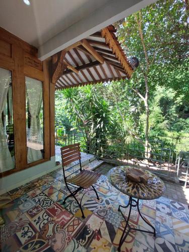 un patio con tavolo e sedia su un pavimento a mosaico di RAYA by Snooze a Yogyakarta