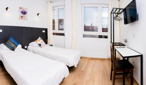 een hotelkamer met 2 bedden en een televisie bij GOLDEN TORREJON in Torrejón de Ardoz