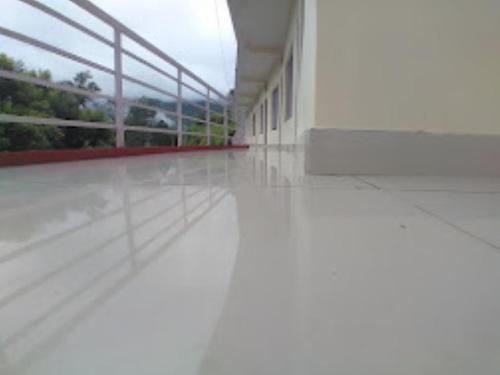 an empty hallway of a building with a white floor at Hotel Vikram Palace Sapeta in Barkot