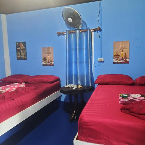 een kamer met twee bedden en een blauwe muur bij Two Rocks Bungalows in Baan Tai