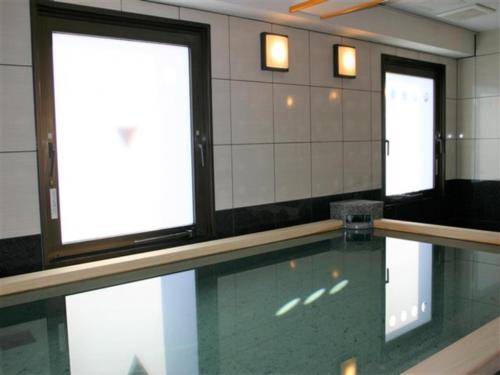 a swimming pool in a room with two windows at Hotel Alpha-One Tsuyama in Tuyama