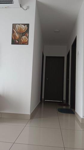 einen Flur mit einer Tür und einem Gemälde an der Wand in der Unterkunft Desaru Utama Residence Homestay in Bandar Penawar