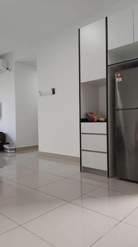 eine Küche mit weißen Schränken und einem Kühlschrank in der Unterkunft Desaru Utama Residence Homestay in Bandar Penawar