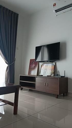 ein Wohnzimmer mit einem Flachbild-TV auf einem Schrank in der Unterkunft Desaru Utama Residence Homestay in Bandar Penawar