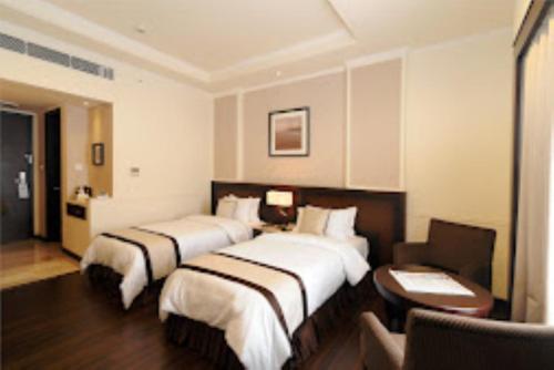 a hotel room with two beds and a desk at Hotel Blue Saphire Countryside Haldwani in Haldwāni