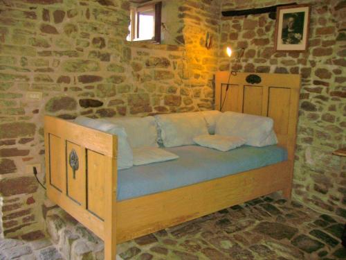 Posto letto in camera con parete in pietra. di Antico-Borgo-Le-Torricelle-Studio a Piandimeleto