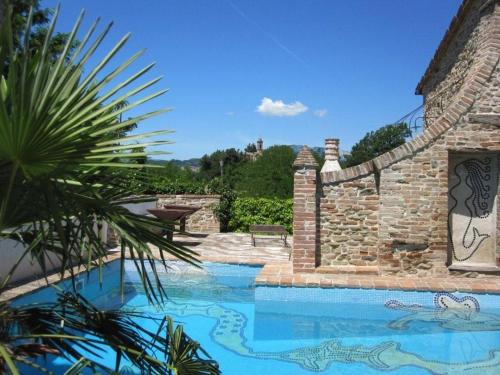 una piscina in un cortile con un muro di pietra di Antico-Borgo-Le-Torricelle-Studio a Piandimeleto
