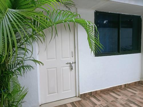 a white door with a plant next to it at Royal Touch Beach Huts in Palolem