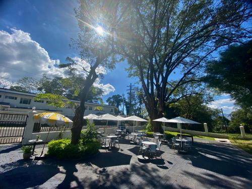 a patio with tables and chairs and umbrellas at Studio type with Free Parking in Kababae