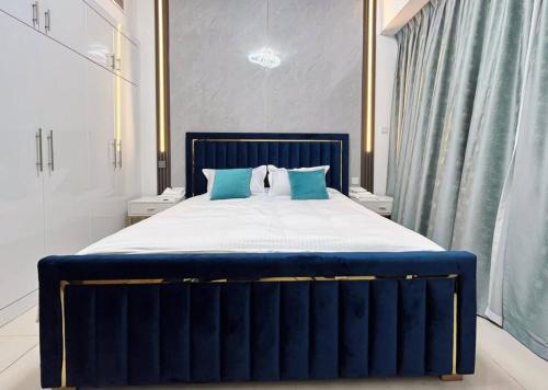 a blue bed with blue pillows in a bedroom at Lux High Rise Marina Apartment in Dubai